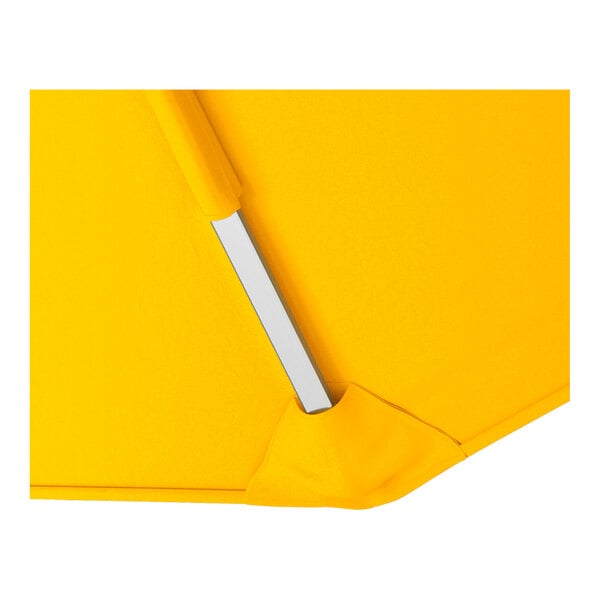 A close-up of a yellow cantilever umbrella with a silver aluminum support.