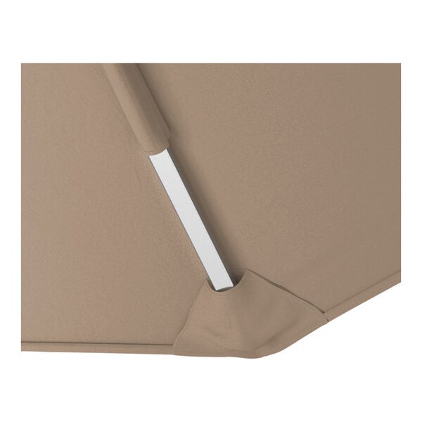 A close-up view of a taupe cantilever umbrella canopy with a silver aluminum support rib.