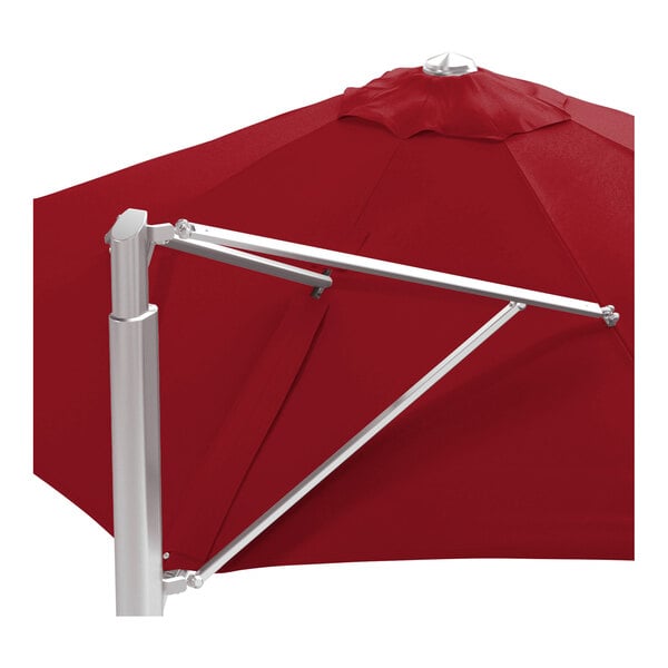 A large round cantilever umbrella with a jockey red canopy and a silver aluminum base.