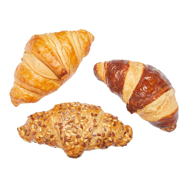 An assortment of three ready-to-bake mini croissants, including plain, chocolate, and seeded varieties.