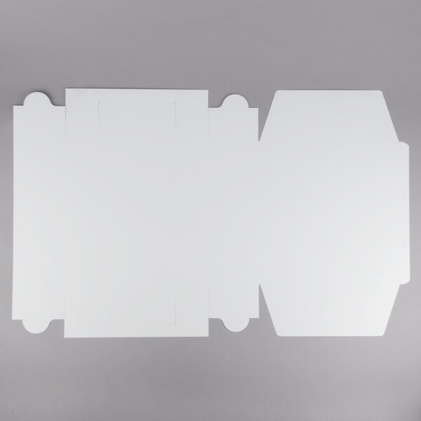 A flat, unfolded white cardboard bakery box designed for cakes or pastries.