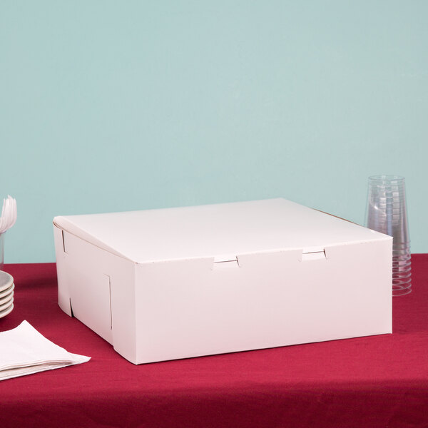 A plain white bakery box with a closed lid, measuring 14 by 14 by 6 inches.