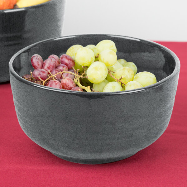 A Tablecraft granite cast aluminum fruit bowl filled with grapes on a table in a salad bar.