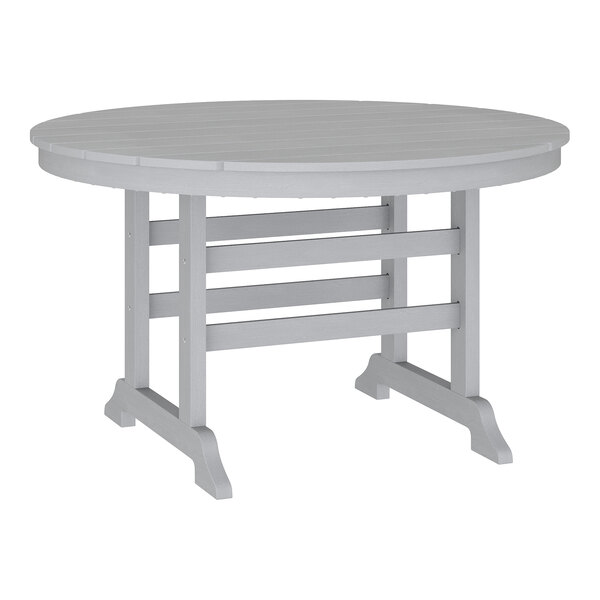A round, gray outdoor table with a slatted top and sturdy legs.