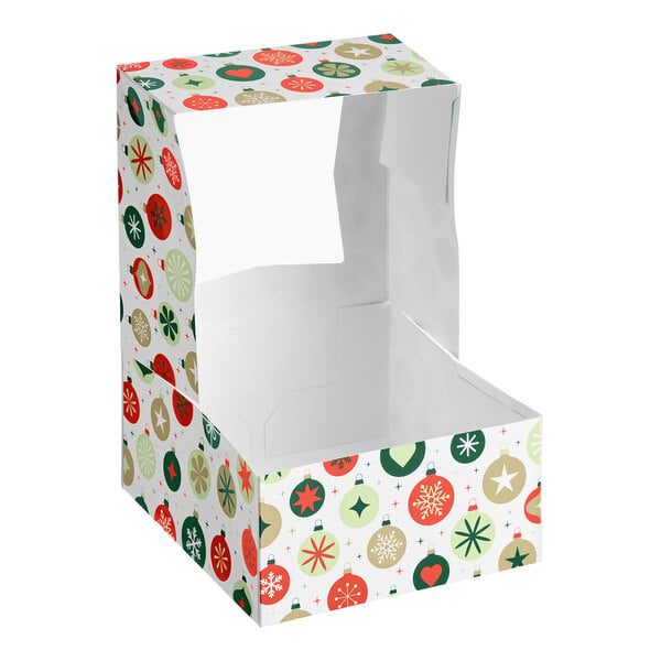 A festive bakery box with a clear window and a colorful ornament pattern in red, green, and gold.