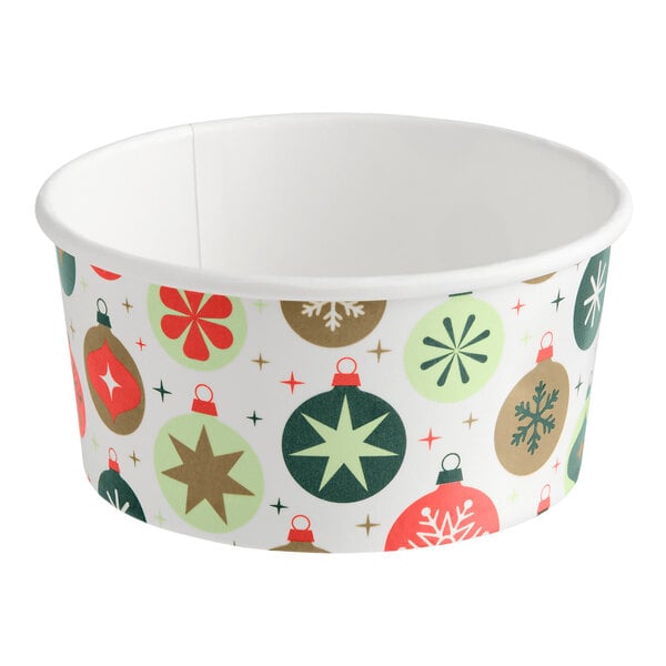 A white paper food cup decorated with colorful Christmas ornament designs in red, green, and gold.