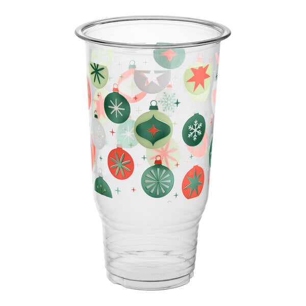 A clear plastic cup decorated with colorful Christmas ornament designs in green, red, and white.