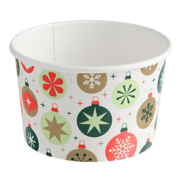 A paper food cup decorated with colorful Christmas ornament designs in red, green, and gold tones.
