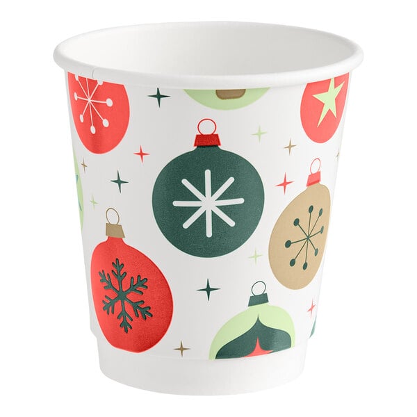 A paper cup decorated with colorful Christmas ornament designs and star patterns.