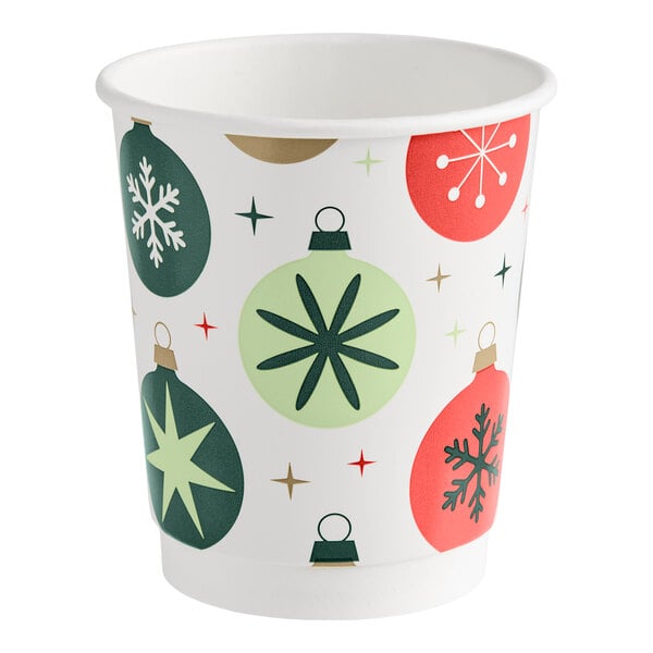 A paper cup decorated with colorful Christmas ornament designs and star patterns.
