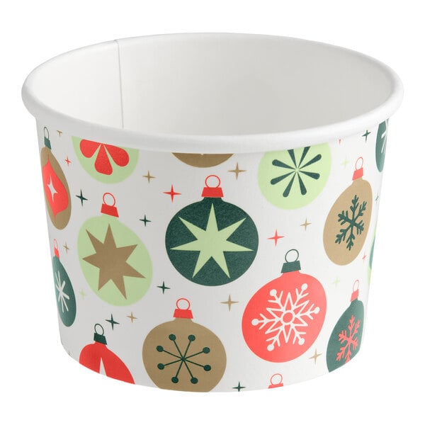 A white paper food cup decorated with colorful Christmas ornament designs in red, green, and gold.