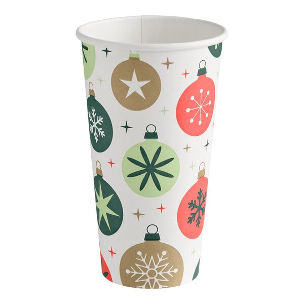 A paper cup decorated with colorful Christmas ornament designs in green, gold, and red tones.