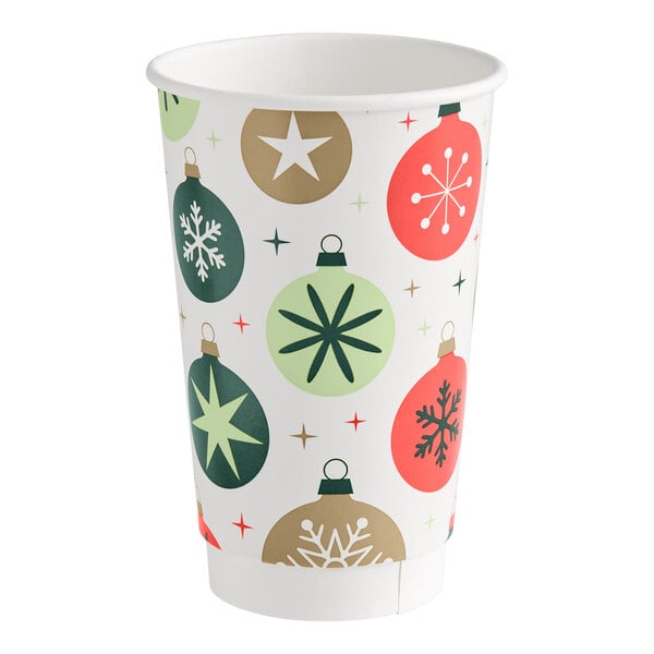 A paper cup decorated with colorful Christmas ornament designs in green, red, and gold tones.