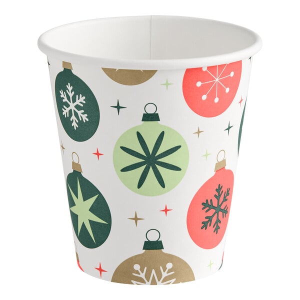 A paper cup decorated with colorful Christmas ornament designs and star patterns.