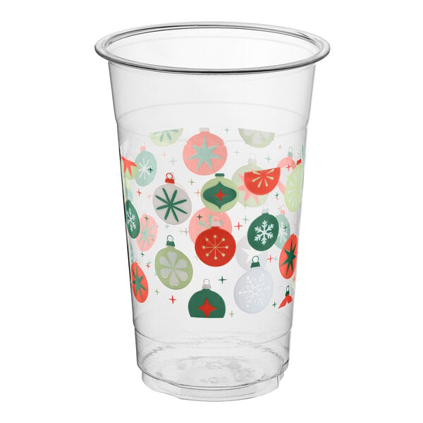 A clear plastic cup decorated with colorful Christmas ornament designs in red, green, and white.