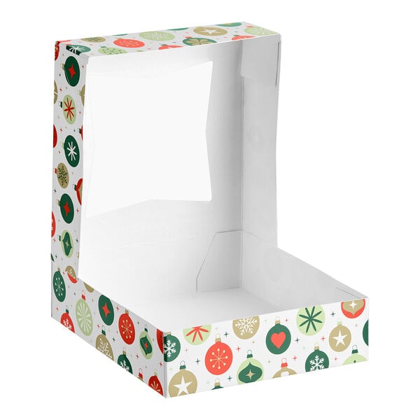 A festive bakery box with a holiday ornament pattern and a clear window on the lid, shown open and empty.