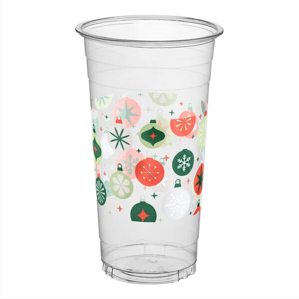 A clear plastic cup decorated with colorful holiday ornament designs in green, red, and white.