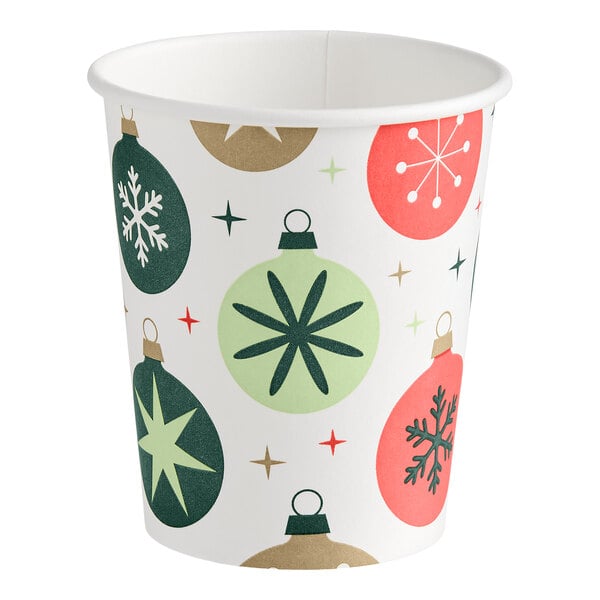 A paper cup decorated with colorful Christmas ornament designs and star patterns.