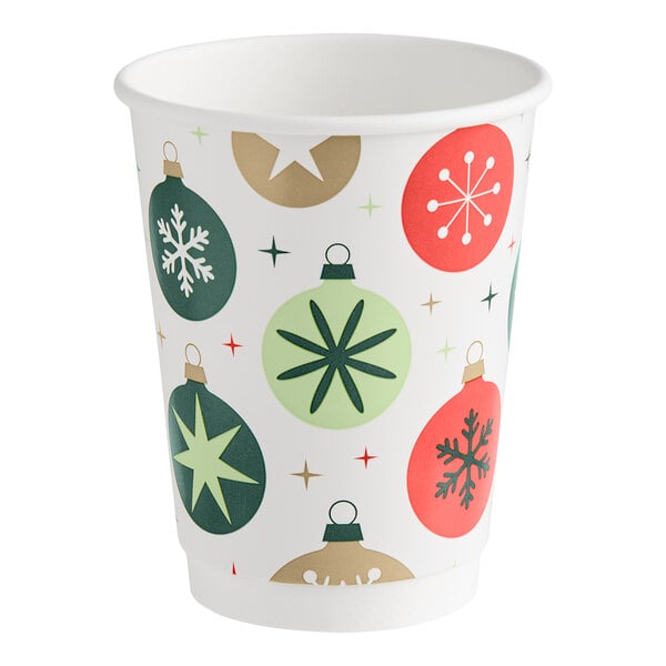 A paper cup decorated with colorful Christmas ornament designs and star patterns.