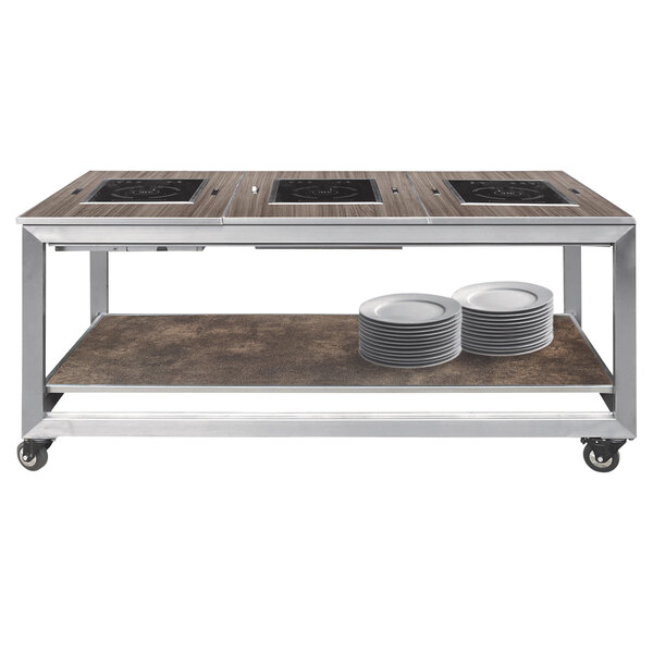 A mobile buffet station with a wood-finish top, built-in induction cooktops, a lower shelf, and caster wheels.