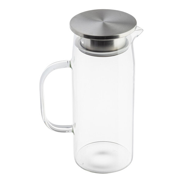 A clear glass pitcher with a handle and a stainless steel lid.