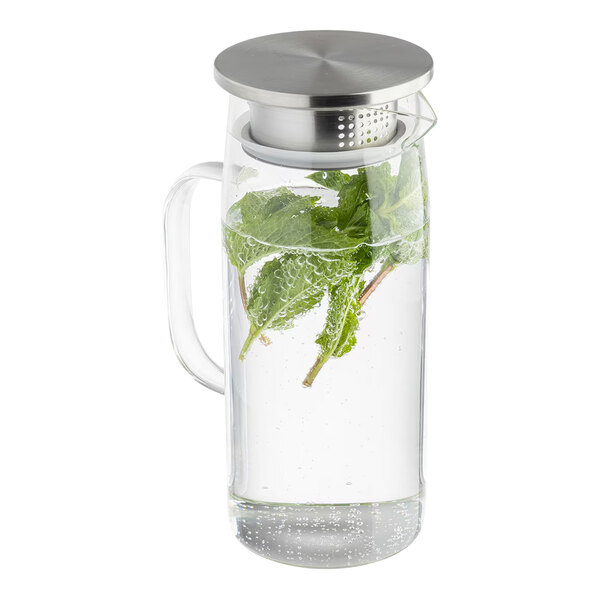A glass pitcher with a handle and a stainless steel lid, filled with water and mint leaves.