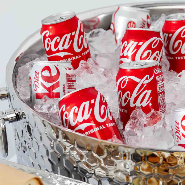 A stainless steel beverage tub filled with ice and cans of Coca-Cola and Diet Coke.