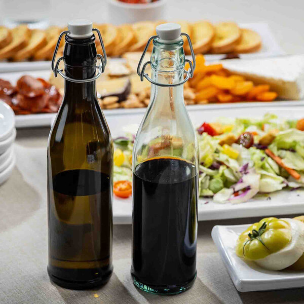 A green-tinted glass cruet with a stopper, designed for holding liquids such as oil or vinegar.