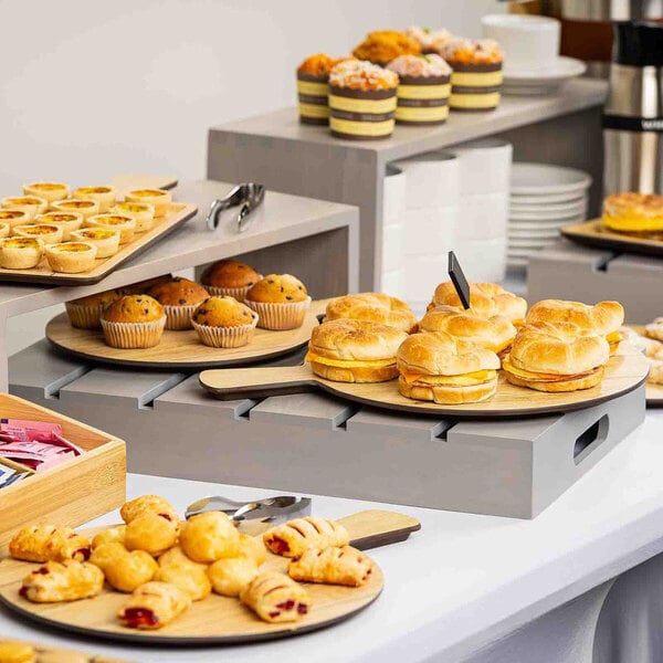 A gray wood serving and display crate used for presenting assorted pastries and baked goods.