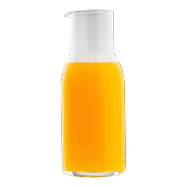 A clear glass carafe filled with orange liquid, likely juice.