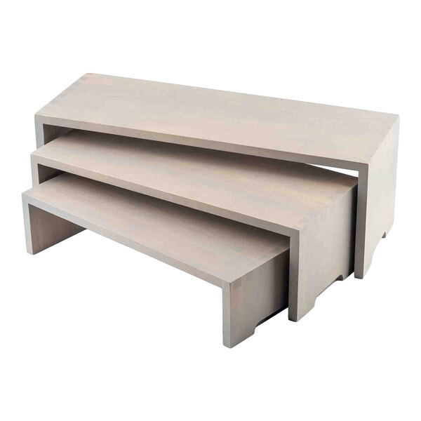 A set of three rectangular gray wood risers that nest together in graduated sizes.