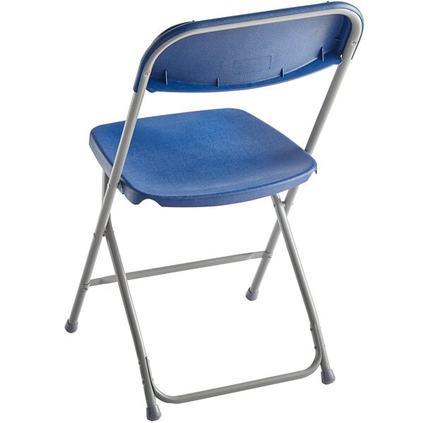 A blue folding chair with a contoured plastic seat and backrest, supported by a light gray metal frame.