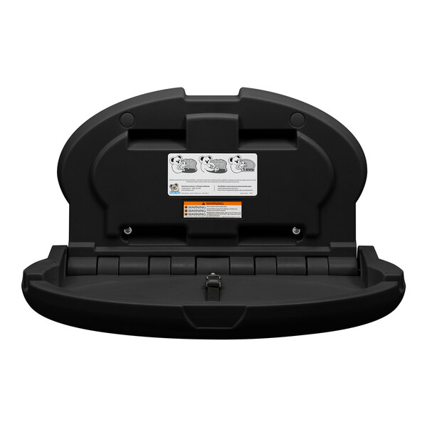 A black, wall-mounted, horizontal oval baby changing station with safety strap and instructional labels visible on the inside surface.