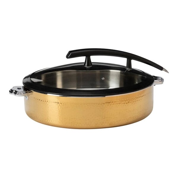 A round, gold-colored hammered steel buffet server with a glass lid and black handle.