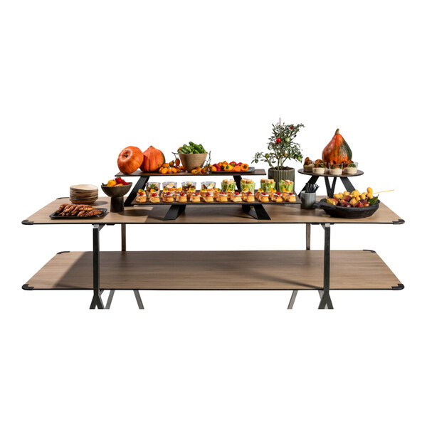 A rectangular, concrete gray riser is placed on a wooden table and is used to elevate food displays.