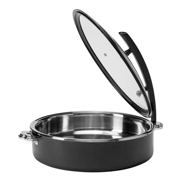 A round black and silver metal buffet server with a glass lid that is propped open.