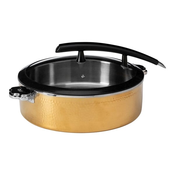 A round, gold-colored hammered steel pot with a glass lid and a black handle.