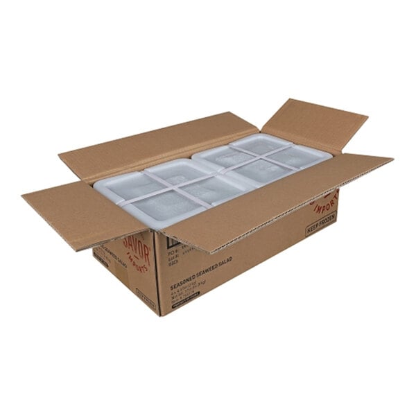 A cardboard case containing four trays of Savor Imports seaweed salad.