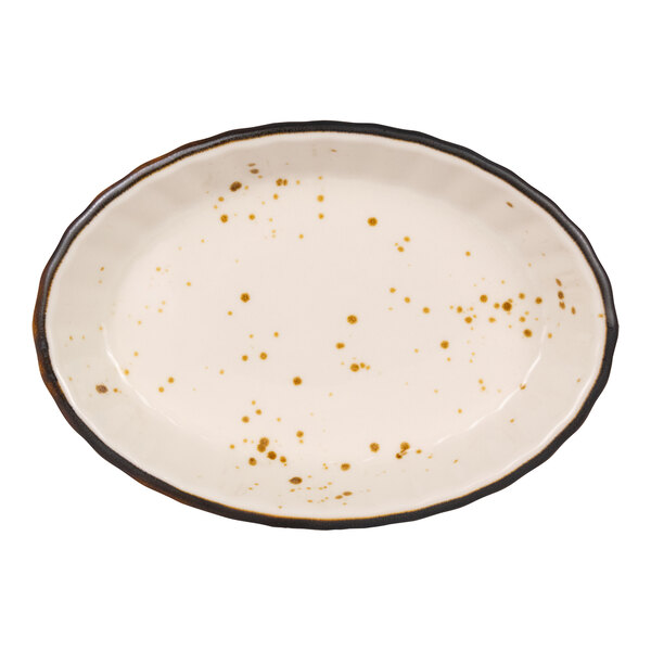 An oval-shaped, cream-colored dish with brown speckles and a dark, irregular rim.
