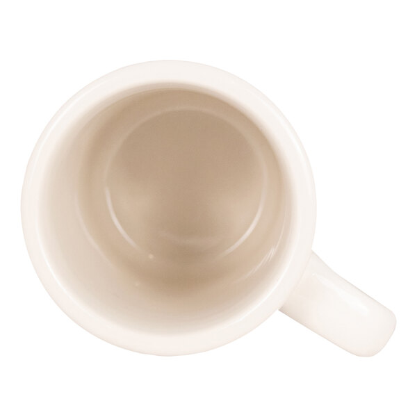 A top-down view of an empty white ceramic mug with a handle.