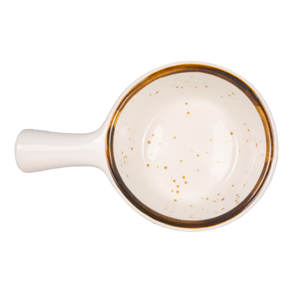 A round, cream-colored ceramic soup crock with a handle, brown rim, and speckled pattern inside.