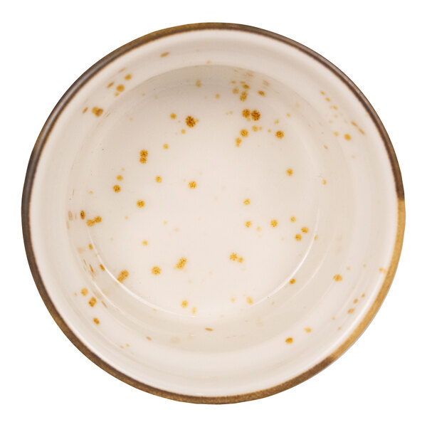 A round, cream-colored ramekin with brown speckles and a slightly darker rim, viewed from above.