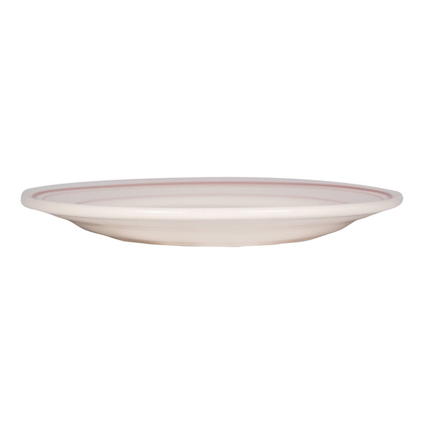 A round, shallow, white plate with a red band near the rim, viewed from the side.