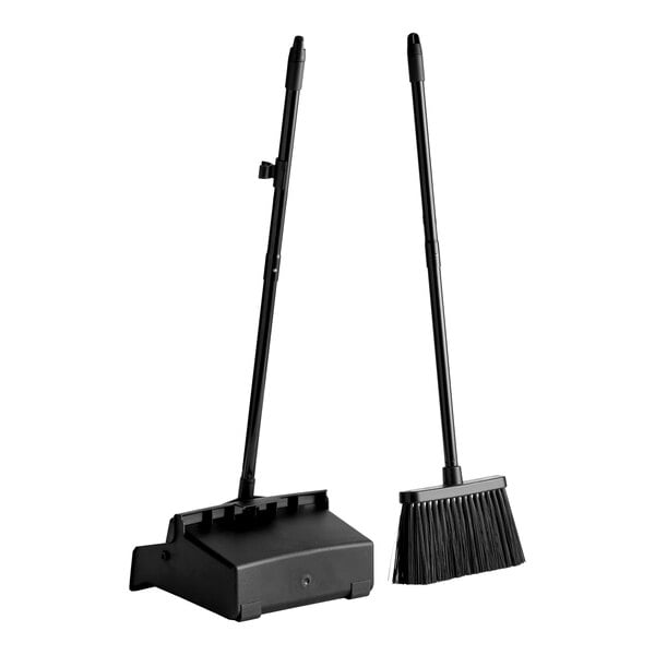 Two black cleaning tools are shown: a long-handled dustpan with an open lid and a matching broom with stiff bristles, both standing upright.