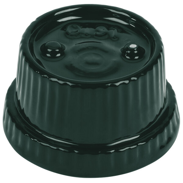 A Tablecraft hunter green cast aluminum souffle bowl with ridges on a table with a black plastic lid with a hole in it.