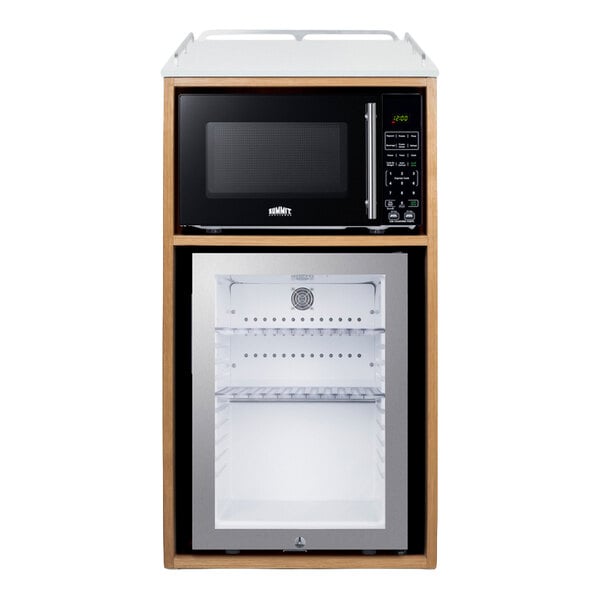 A wooden cabinet contains a black microwave on top and a glass-door minibar refrigerator below.