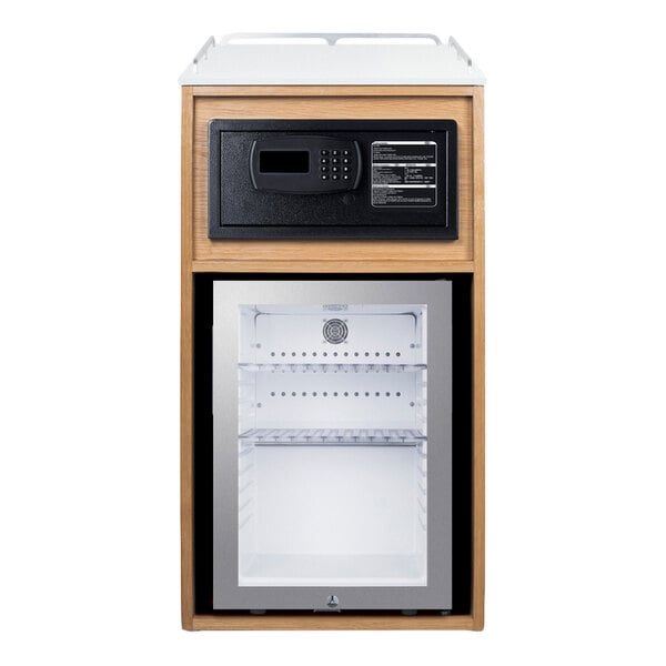 A wooden cabinet features a digital safe on the upper section and a glass-door minibar refrigerator below.