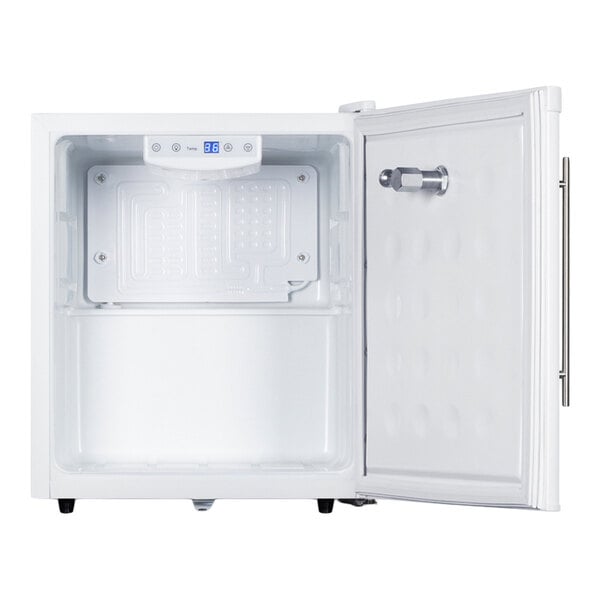 An open, empty white appliance with a digital display and control panel at the top inside, and a door with a metal tap or spout attached.