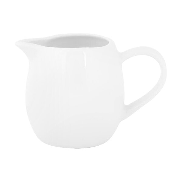 A small white porcelain creamer with a handle and spout.