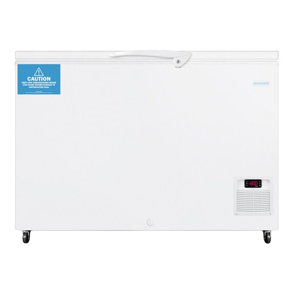A large white chest freezer with a digital temperature display, a caution label, and caster wheels at the bottom.